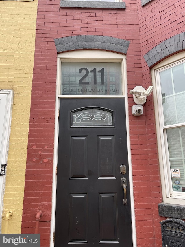 view of exterior entry featuring brick siding