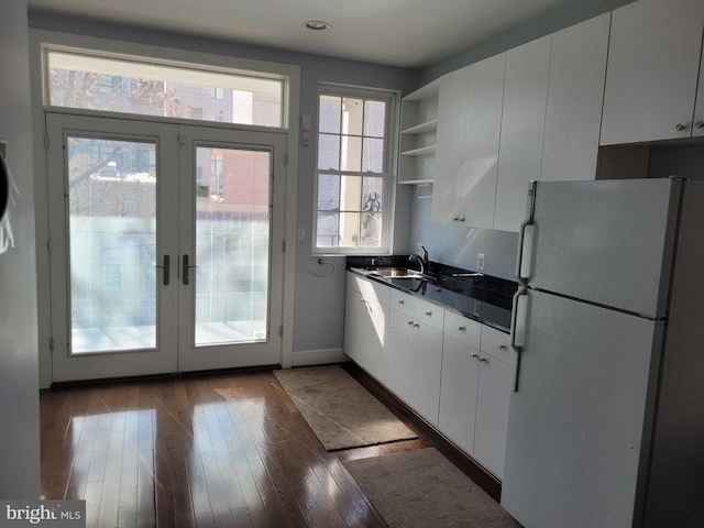 kitchen with dark countertops, white cabinetry, open shelves, and freestanding refrigerator