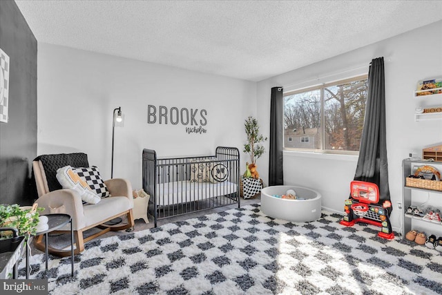 bedroom with a textured ceiling and a crib