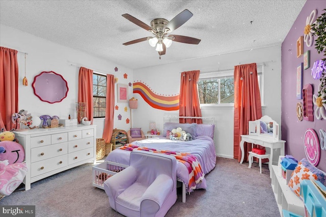 bedroom featuring light carpet, multiple windows, and a textured ceiling