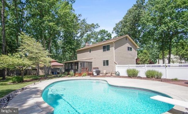 view of pool featuring a deck, a diving board, fence, and a fenced in pool