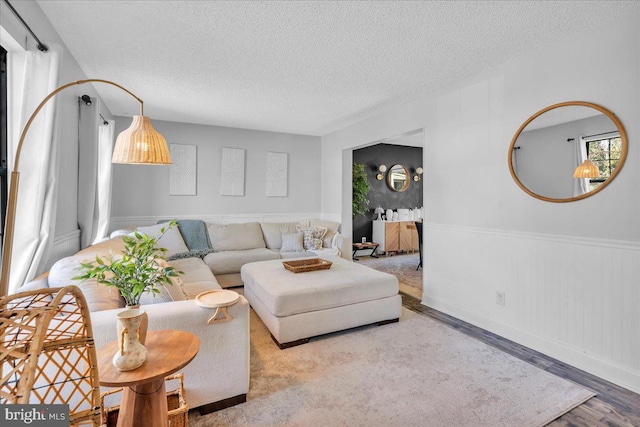 living room with a textured ceiling and light wood finished floors