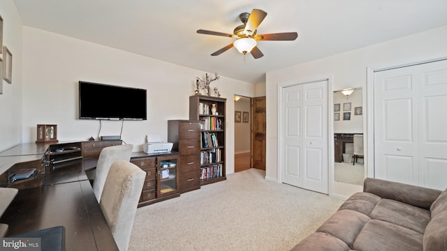 office featuring a ceiling fan and light colored carpet