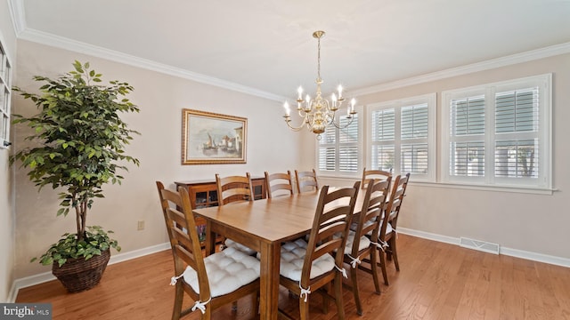 dining area featuring a chandelier, light wood-style flooring, visible vents, baseboards, and ornamental molding