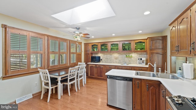 kitchen featuring a skylight, a sink, visible vents, light countertops, and stainless steel dishwasher