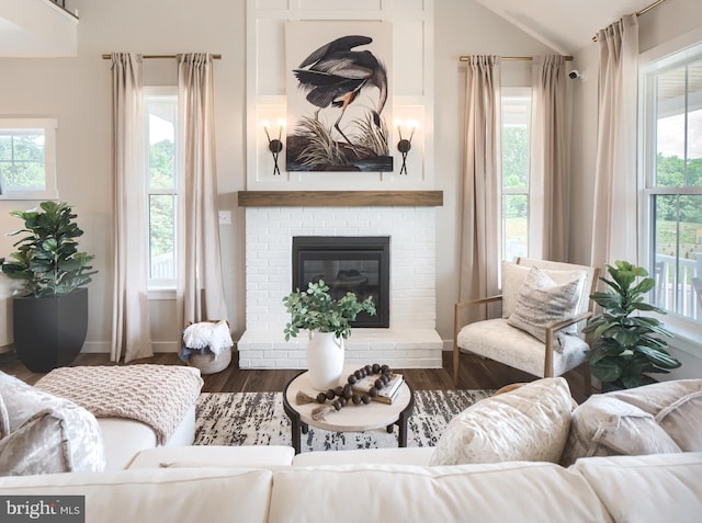 living room with lofted ceiling, dark wood-type flooring, a fireplace, and baseboards