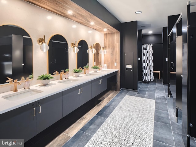 bathroom with double vanity, a sink, and a shower stall