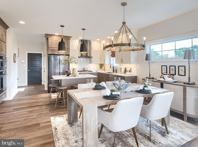 dining room with baseboards, wood finished floors, and recessed lighting