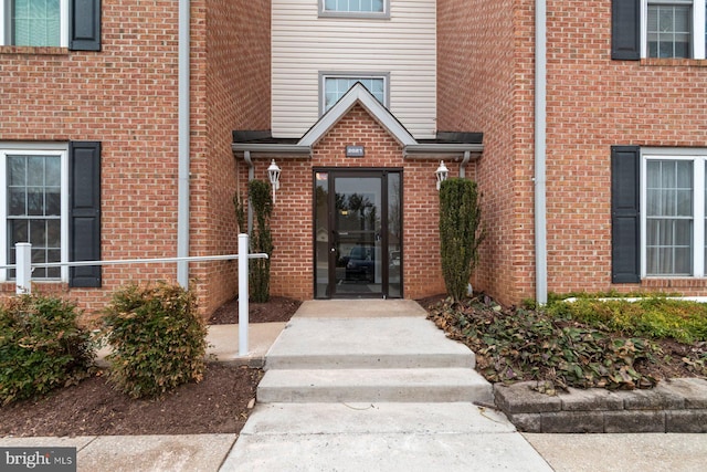 doorway to property with brick siding