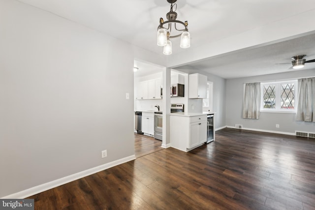 interior space with beverage cooler, visible vents, white cabinets, appliances with stainless steel finishes, and light countertops