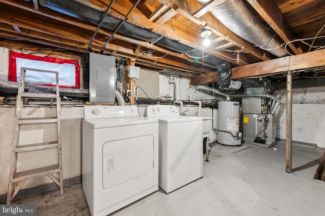 clothes washing area with gas water heater, washing machine and dryer, laundry area, electric panel, and heating unit