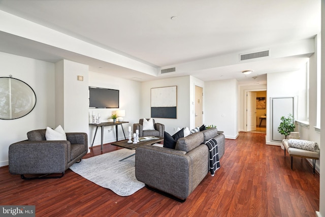 living room featuring baseboards, visible vents, and dark wood-type flooring