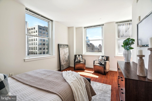 bedroom with dark wood-style flooring and baseboards