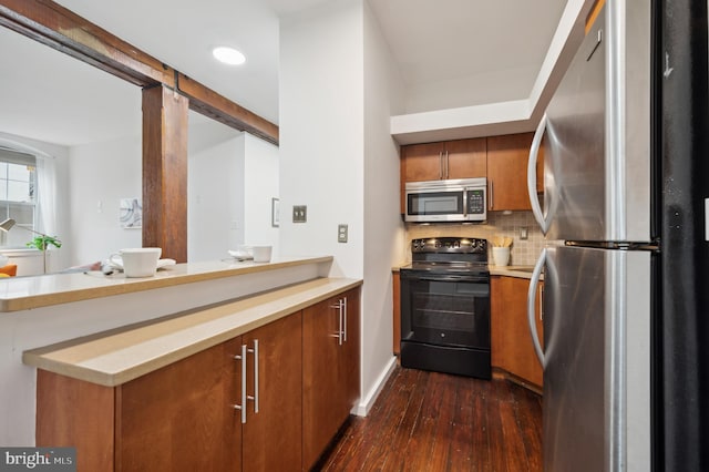 kitchen with dark wood-style flooring, light countertops, appliances with stainless steel finishes, decorative backsplash, and brown cabinetry