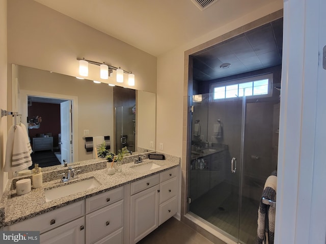 bathroom featuring connected bathroom, a sink, a shower stall, and double vanity