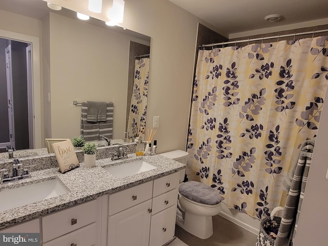 bathroom featuring a sink, toilet, and double vanity