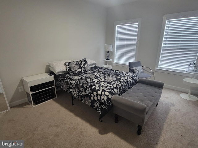 bedroom featuring baseboards and light colored carpet