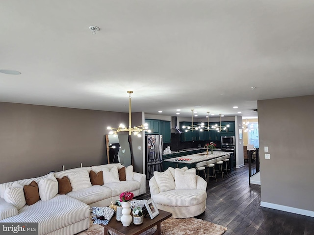 living area featuring an inviting chandelier, baseboards, dark wood-type flooring, and recessed lighting