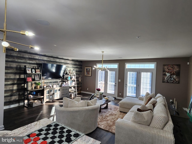 living area featuring dark wood-style floors, an inviting chandelier, and baseboards