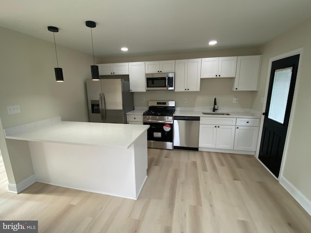 kitchen with light wood-style flooring, white cabinetry, stainless steel appliances, and a sink