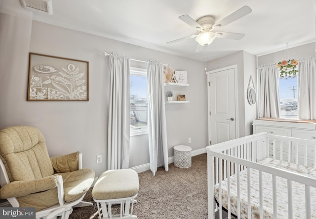 bedroom with visible vents, multiple windows, a nursery area, and baseboards