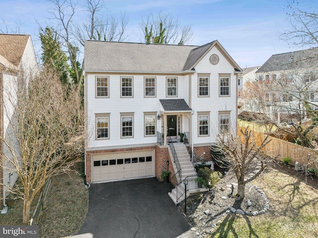 view of front of property with a garage, a shingled roof, fence, and aphalt driveway