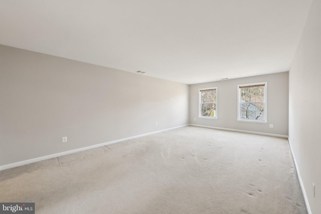 carpeted empty room featuring visible vents and baseboards