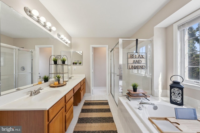 bathroom featuring double vanity, a shower stall, a sink, and tile patterned floors