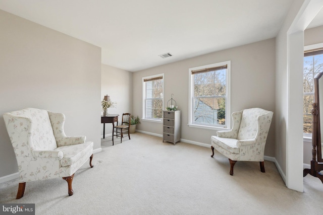 sitting room with baseboards, visible vents, and carpet flooring