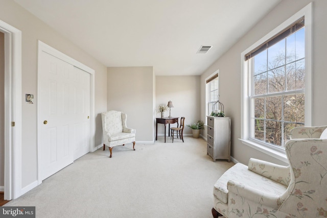 living area with carpet floors, baseboards, and visible vents