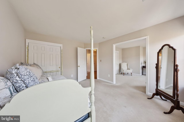 bedroom featuring light carpet, a closet, and baseboards