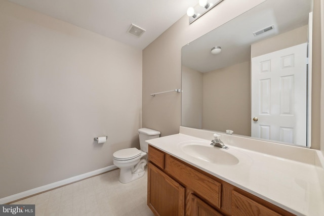 bathroom featuring toilet, vanity, visible vents, and baseboards