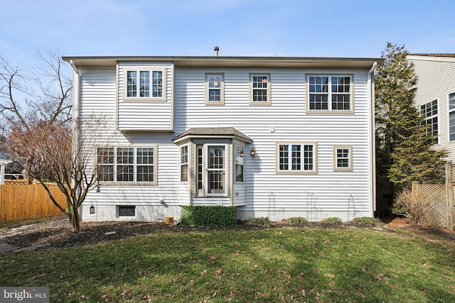 view of front of home with fence and a front lawn