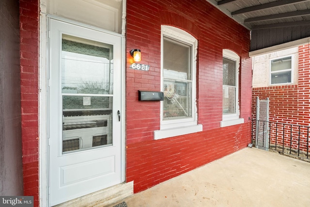 doorway to property featuring brick siding