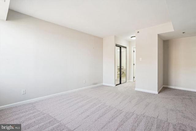 spare room with baseboards and carpet flooring