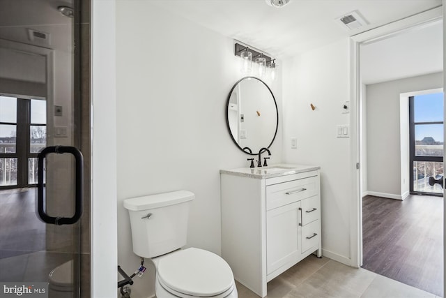 bathroom with visible vents, vanity, toilet, and baseboards