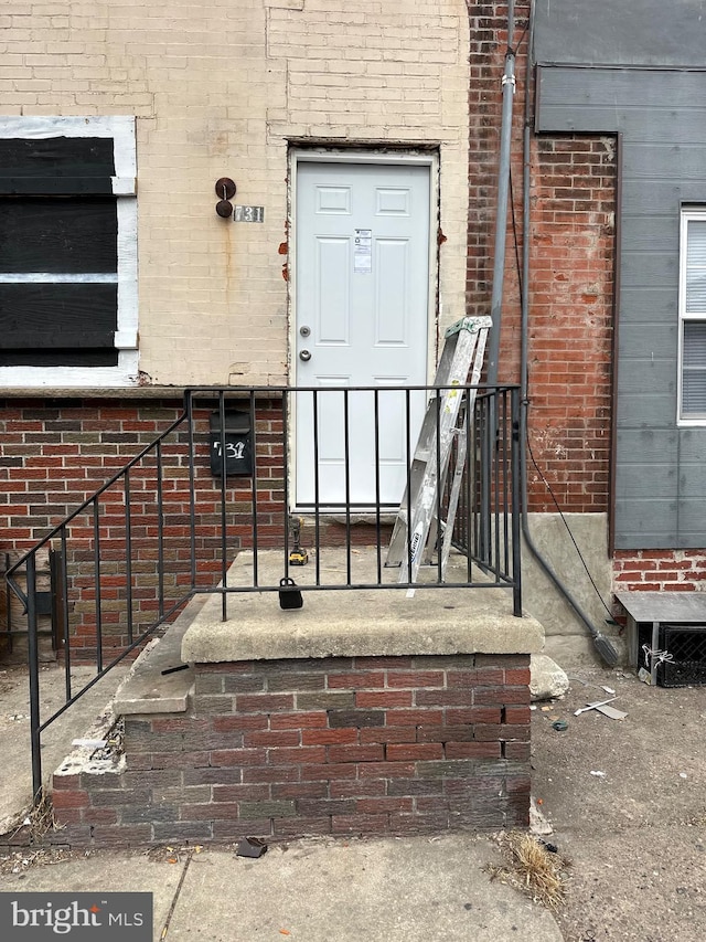 doorway to property with brick siding