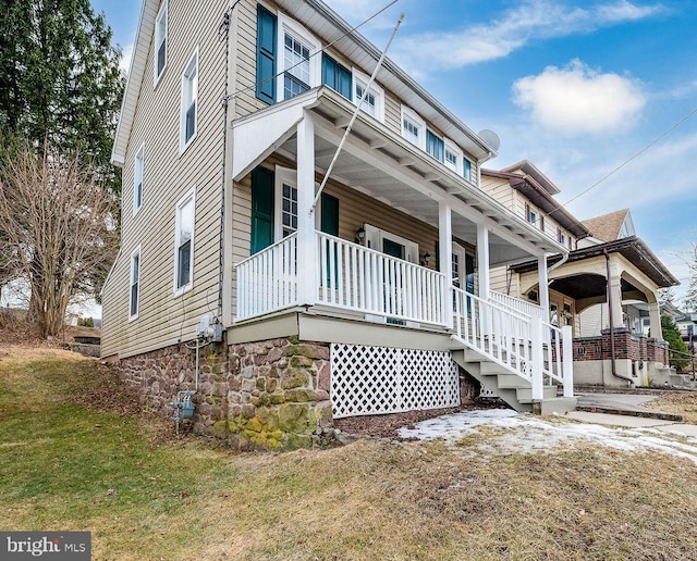 exterior space with covered porch and a front lawn