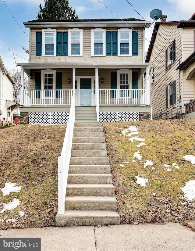 view of front of home featuring covered porch and stairs