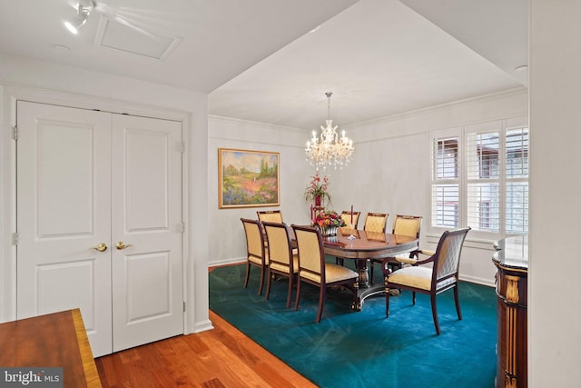 dining space with visible vents, a notable chandelier, ornamental molding, wood finished floors, and baseboards