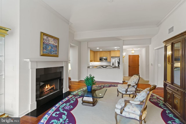 living room with baseboards, crown molding, a lit fireplace, and wood finished floors