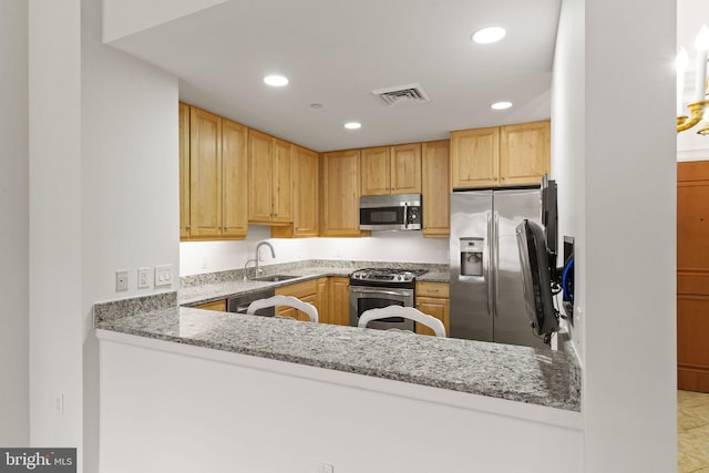 kitchen with light stone countertops, visible vents, recessed lighting, a sink, and stainless steel appliances