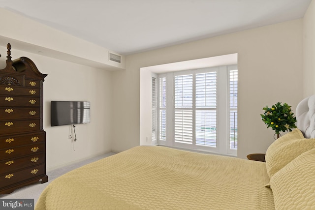 bedroom featuring visible vents and light colored carpet