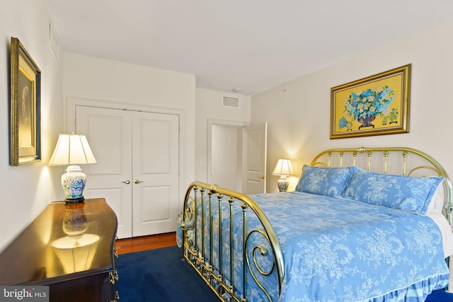 bedroom featuring a closet, visible vents, and wood finished floors