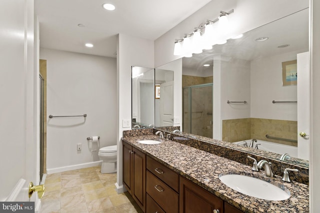 full bath with a sink, toilet, double vanity, and a shower stall