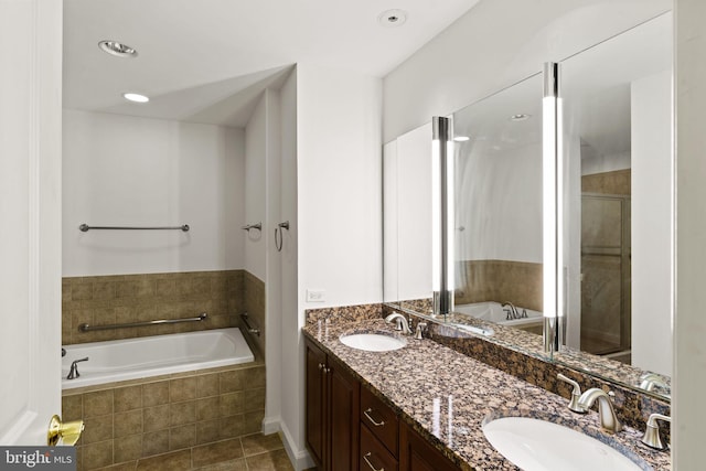 full bath with a sink, a stall shower, a bath, and double vanity