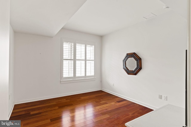 empty room with baseboards and wood finished floors