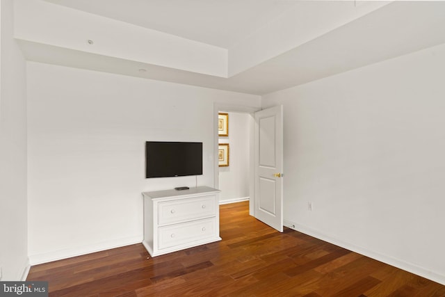 unfurnished bedroom with wood finished floors and baseboards