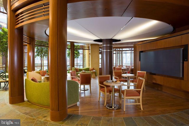 dining area featuring decorative columns, wood finished floors, and floor to ceiling windows