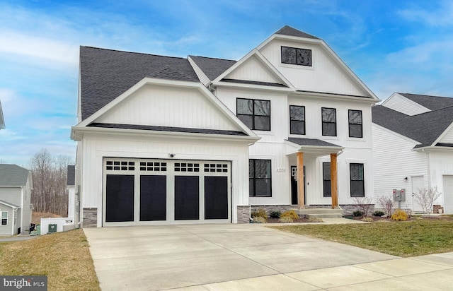 modern farmhouse style home featuring a garage, a shingled roof, driveway, stone siding, and board and batten siding